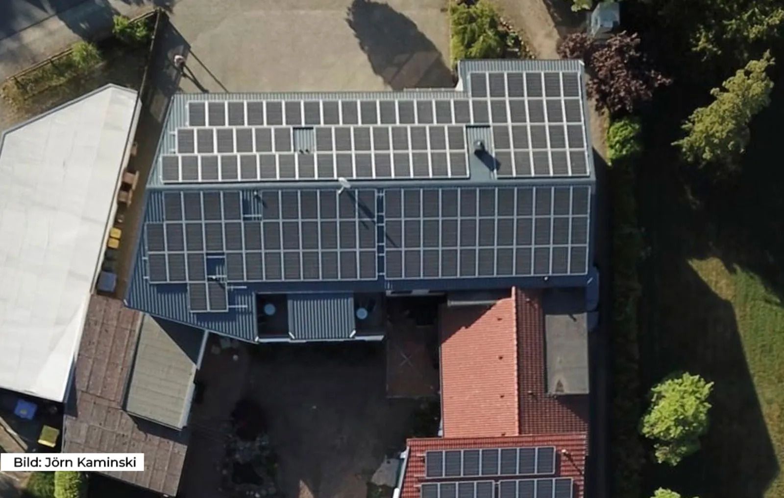Vollflächig mit Solarmodulen belegte Dachflächen eines Wohnhauses aus der Vogelperspektive.